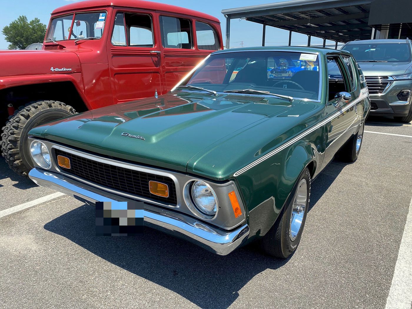Green 1972 AMC Gremlin X from the front three-quarter, with its silver grille surround, amber parking lamps and Gremlin hood script