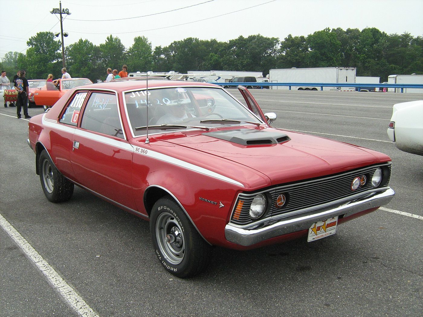 Red 1971 AMC Hornet SC/360 two-door sedan in a drag-strip staging lane, showing the SC 360 stripe and ram-air hood scoop