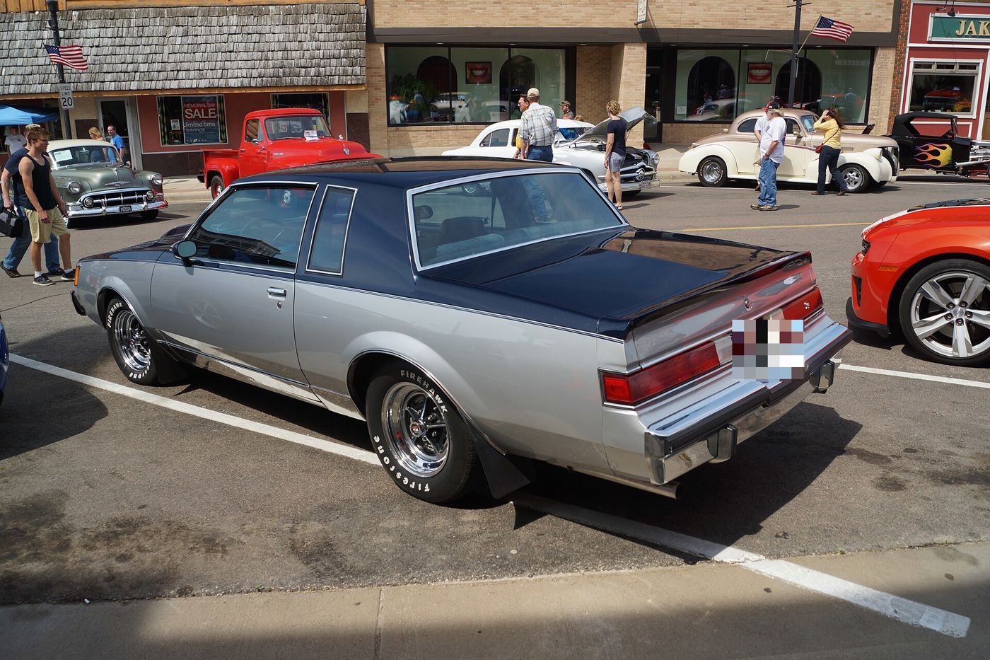 Silver-and-charcoal 1981 Buick Regal coupe from the rear three-quarter, parked on a small-town street