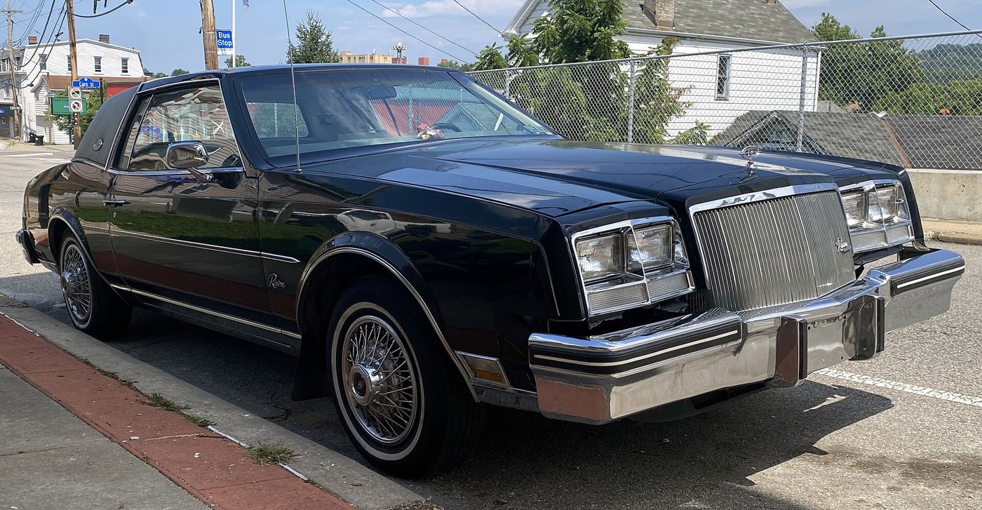 Dark-blue 1980 Buick Riviera coupe, front three-quarter, at a curb