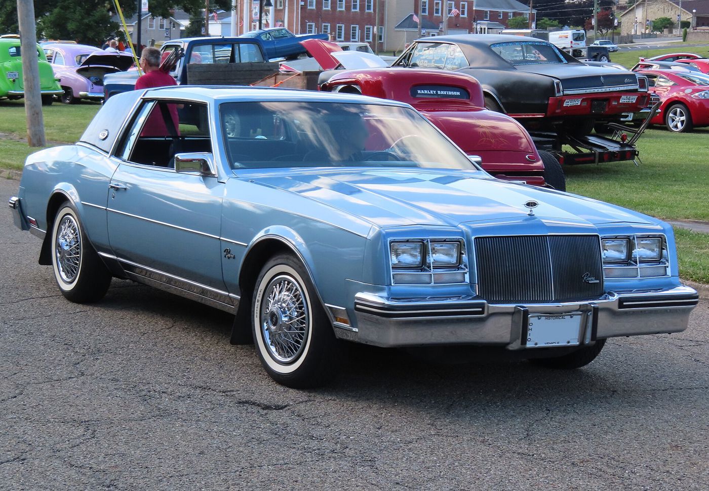 Light-blue 1985 Buick Riviera coupe with wire wheels, front three-quarter, at a car show