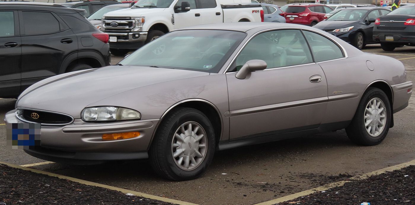 Pale pink-silver 1996 Buick Riviera Supercharged, front three-quarter, in a parking lot