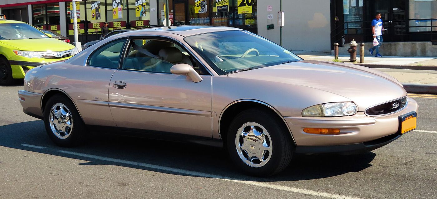 Champagne 1999 Buick Riviera coupe, side view, in a parking lot