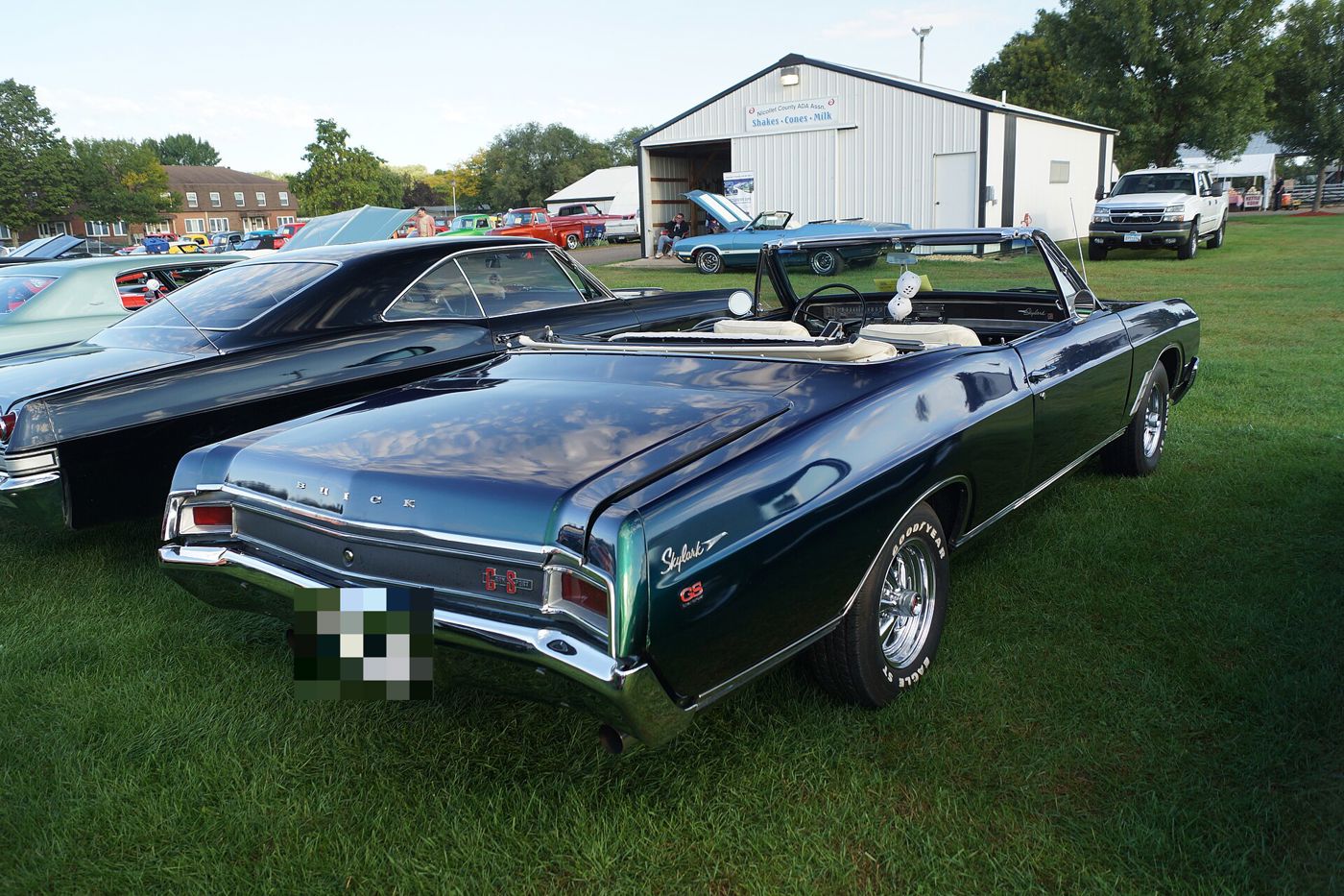 Dark-teal 1966 Buick Skylark Gran Sport convertible from the rear three-quarter, on grass