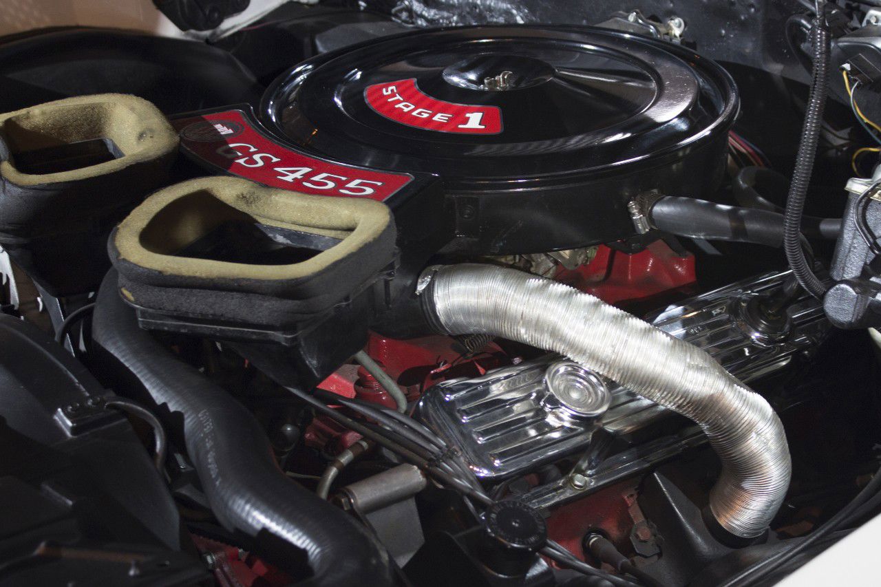 Engine bay of a 1970 Buick GSX: black air cleaner with red Stage 1 and GS 455 decals and the hood-scoop ducts