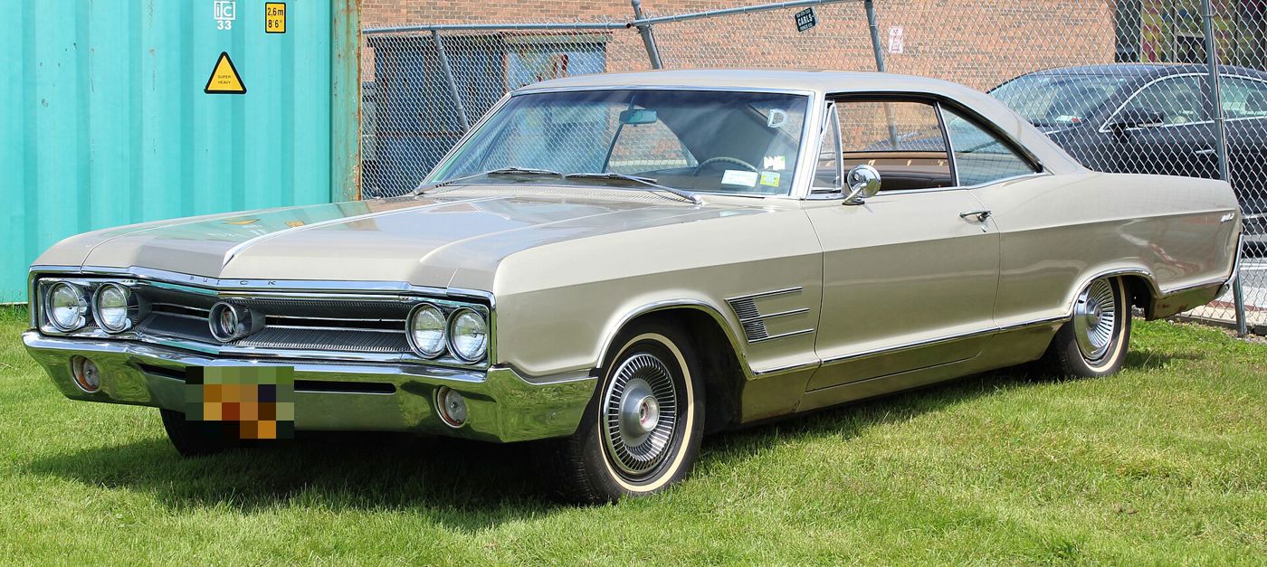 Champagne 1965 Buick Wildcat two-door hardtop, front three-quarter, on grass