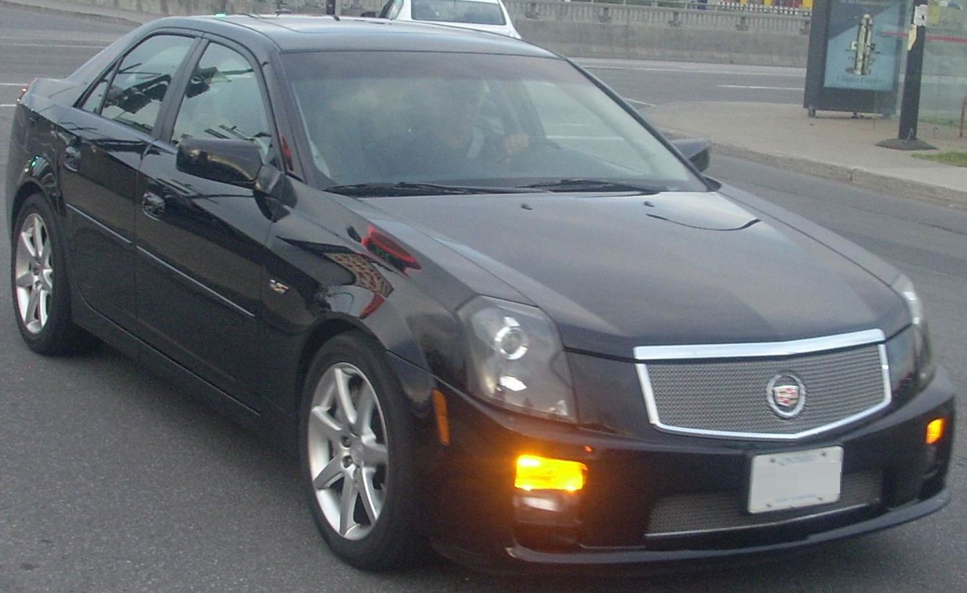 Black first-generation Cadillac CTS-V sedan with mesh grille, front three-quarter