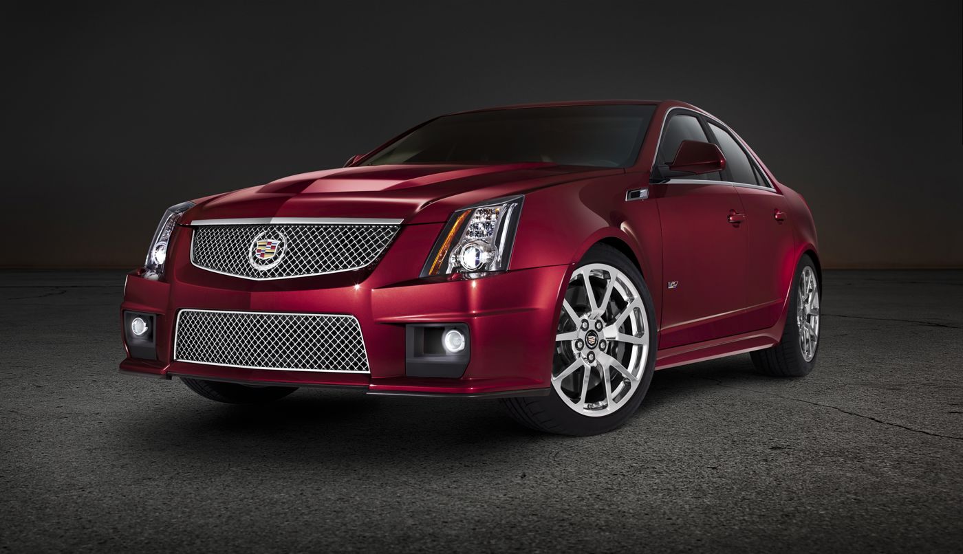 Red 2012 Cadillac CTS-V sedan with mesh grille, front three-quarter, in a dark studio
