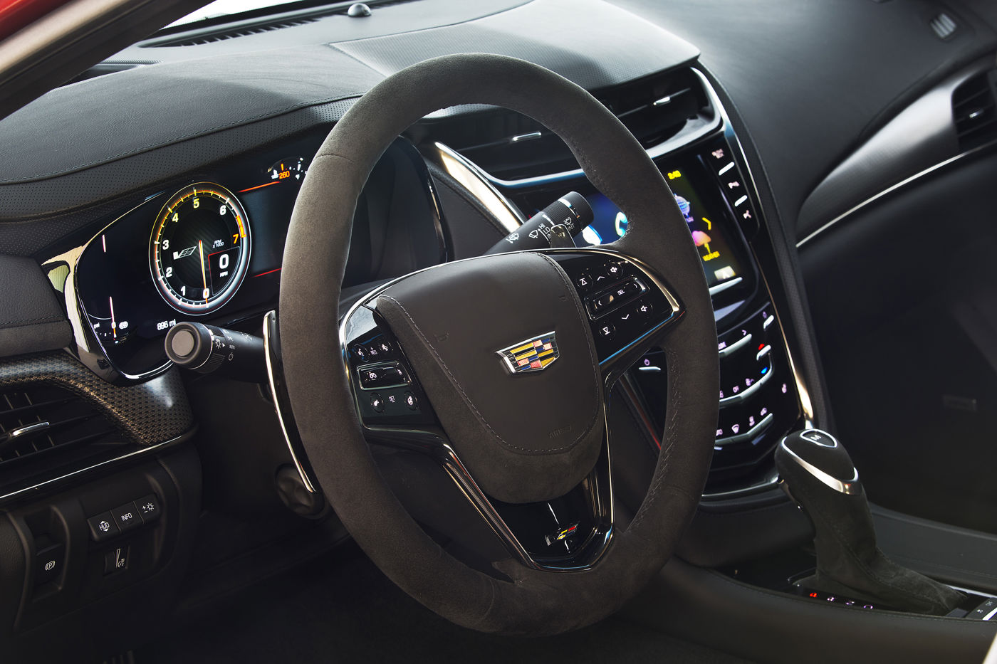 Suede-rimmed steering wheel, digital gauges and center stack of a 2016 Cadillac CTS-V