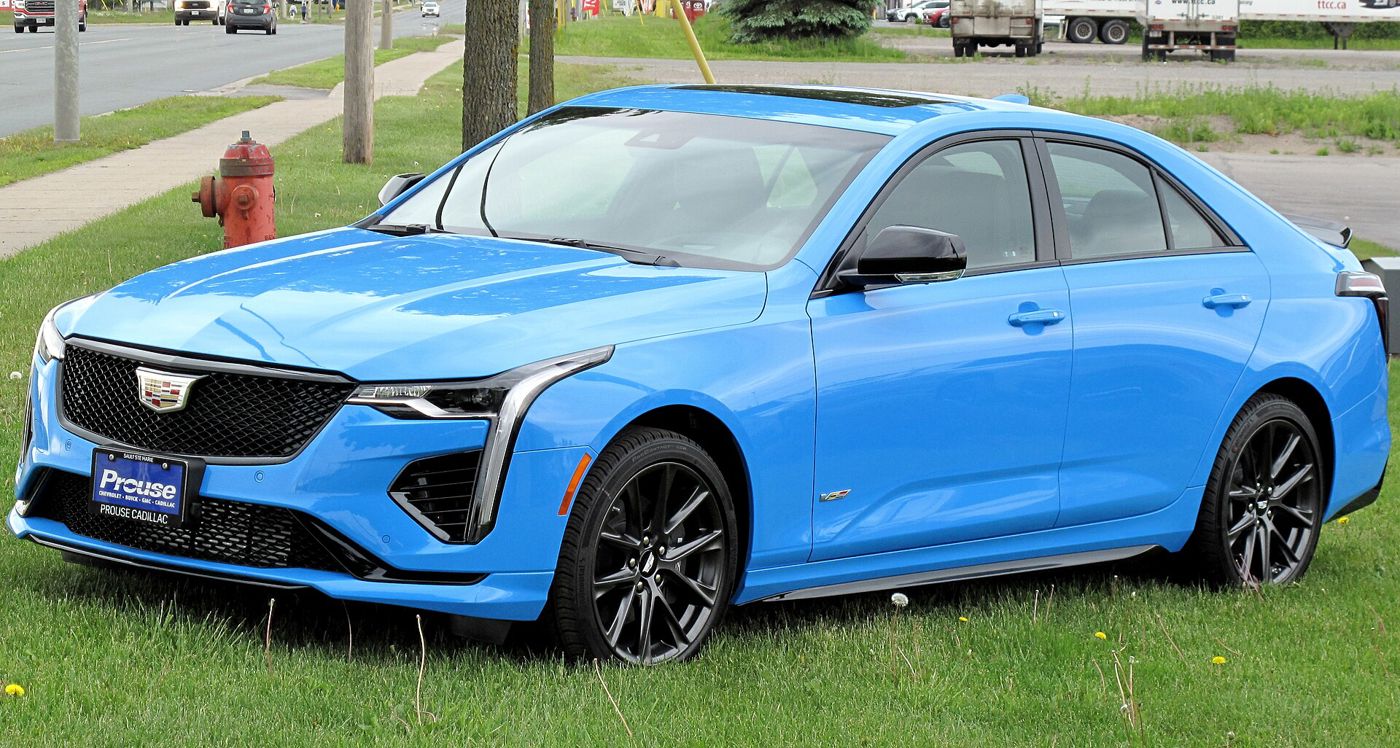 Electric Blue 2022 Cadillac CT4-V sedan, front three-quarter, on grass