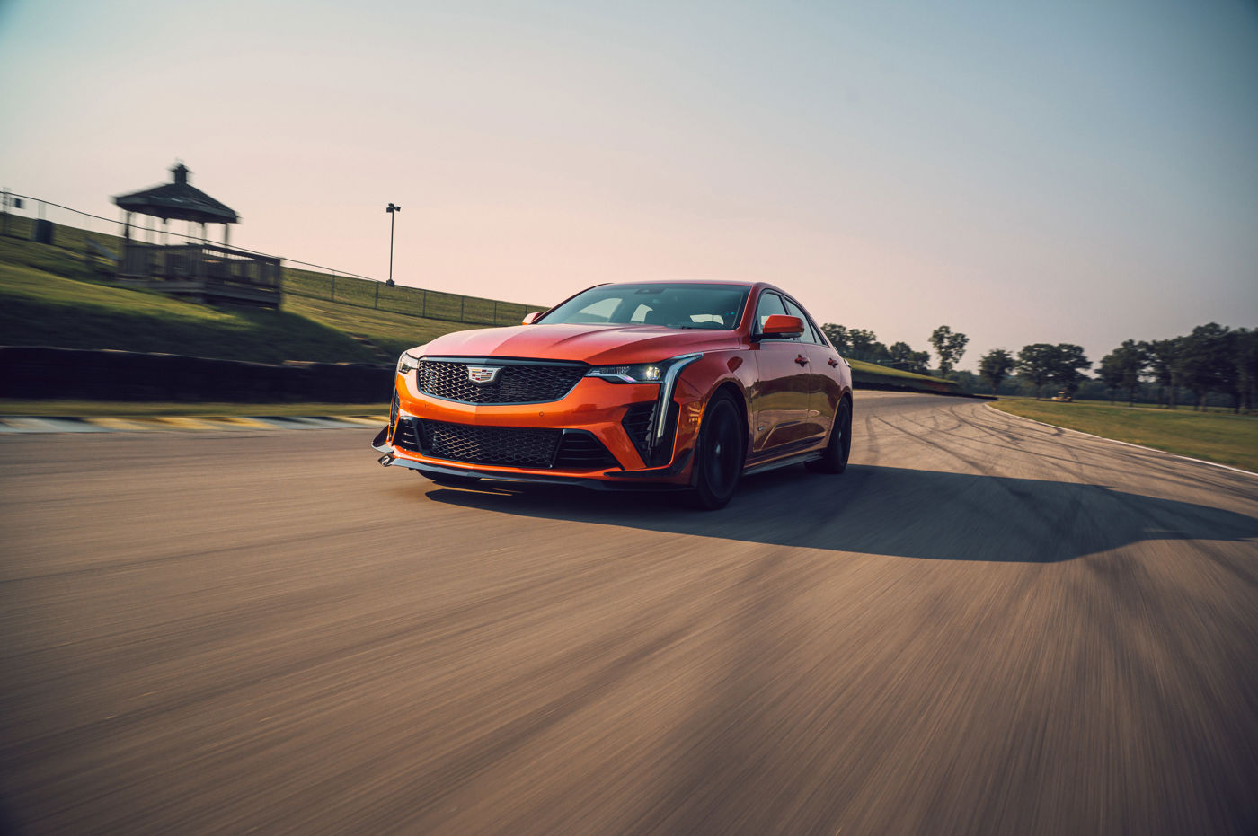 Orange 2023 Cadillac CT4-V Blackwing sedan, front three-quarter, on a racetrack
