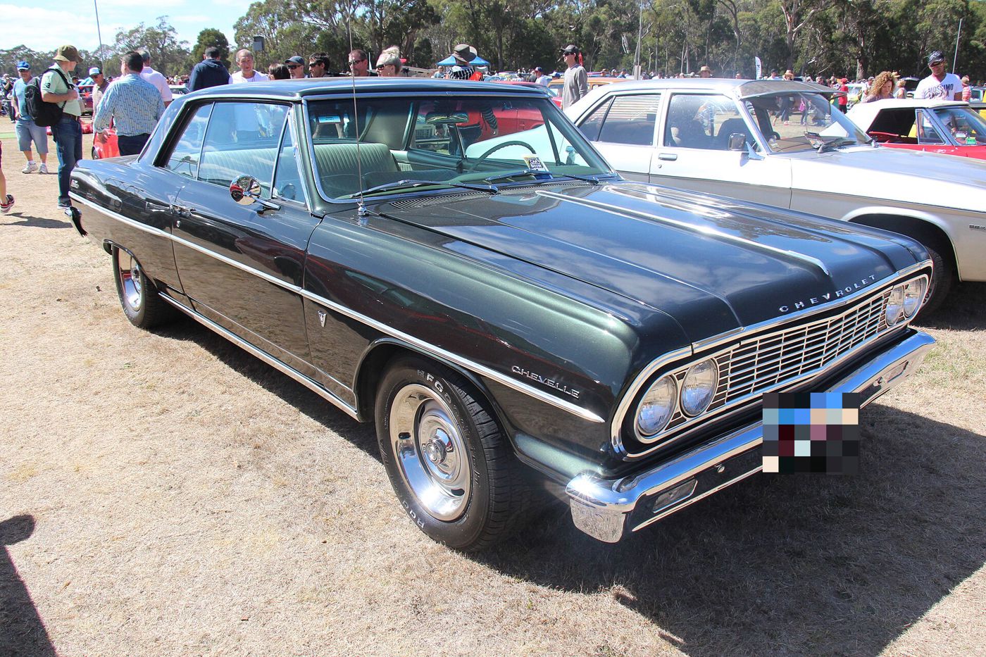Dark green 1964 Chevrolet Chevelle Malibu SS two-door hardtop at an outdoor car show in Australia, front three-quarter, with Chevelle fender script and Malibu SS emblem on the rear quarter