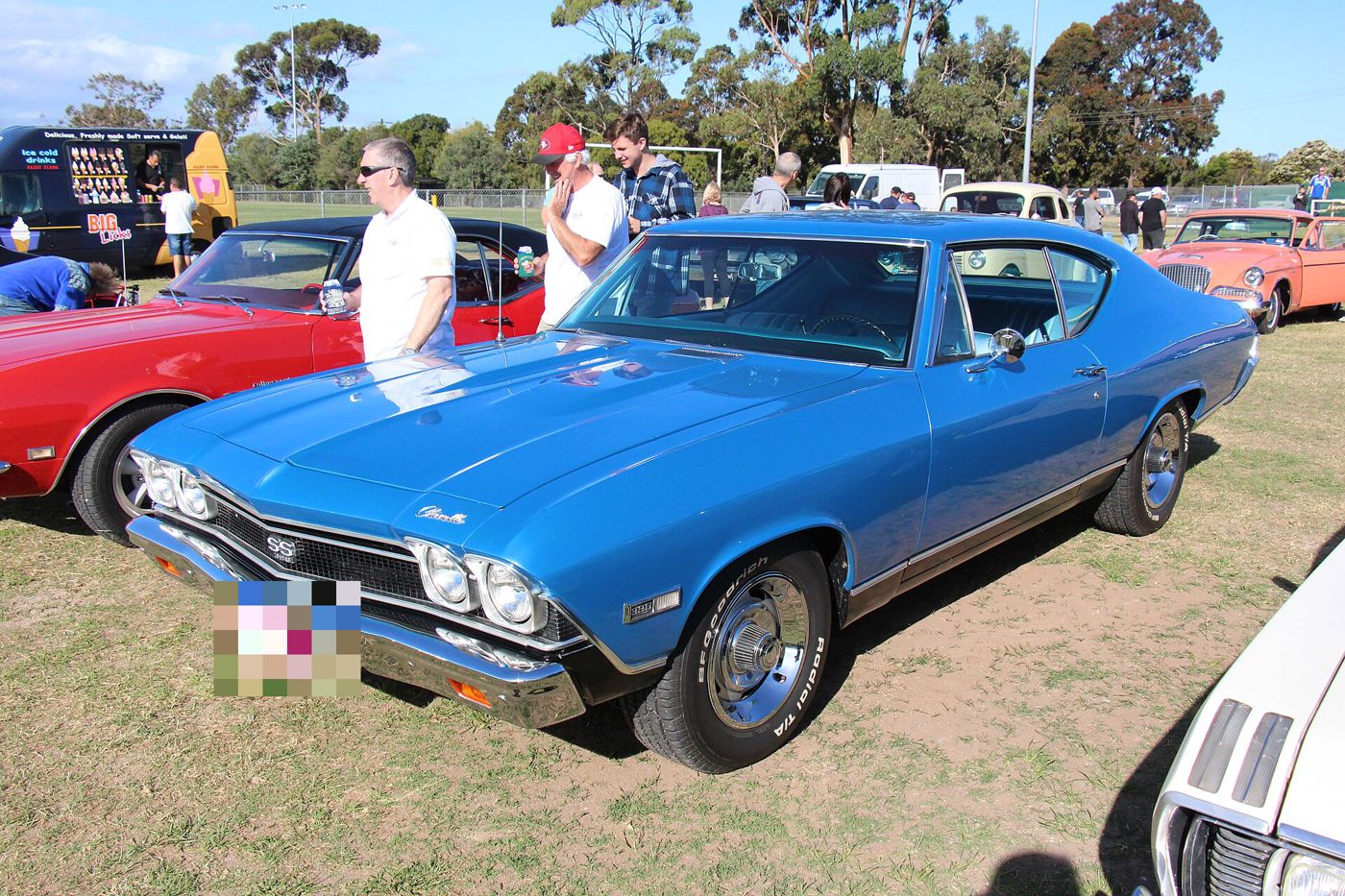 Blue 1968 Chevrolet Chevelle SS 396 two-door hardtop on grass at a car show, front three-quarter, with the SS 396 grille badge, black-out lower body and 396 fender badge