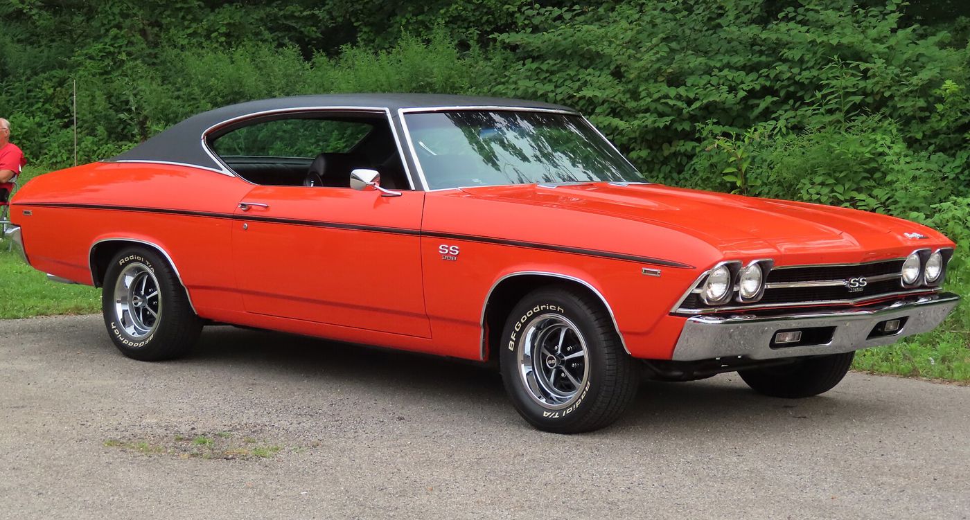 Orange 1969 Chevrolet Chevelle SS 396 two-door hardtop with a black vinyl roof and black side stripe, front three-quarter, with SS 396 grille and fender badges and SS wheels