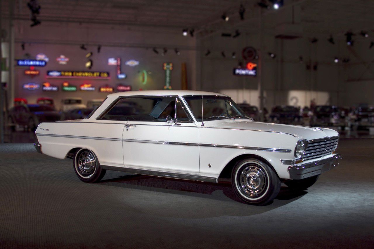 White 1963 Chevrolet Chevy II Nova SS two-door hardtop in the GM Heritage Center hall, side and front three-quarter view, with SS wheel covers and whitewall tires
