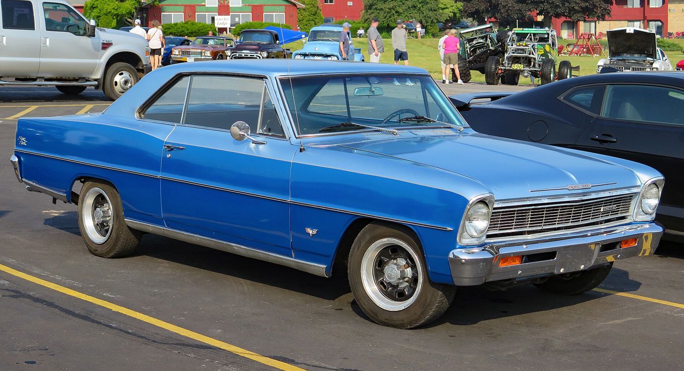 Marina Blue 1966 Chevrolet Chevy II Nova SS two-door hardtop in a parking lot, front three-quarter, with the 1966 grille, crossed-flags fender emblem and Super Sport script on the rear quarter