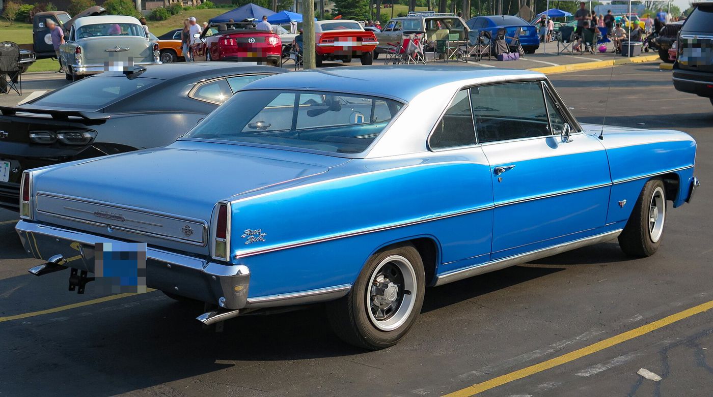 Rear three-quarter of a Marina Blue 1966 Chevy II Nova SS with a silver roof, showing the Super Sport script on the rear quarter, the full-width trim panel between the taillamps and the vertical taillamps