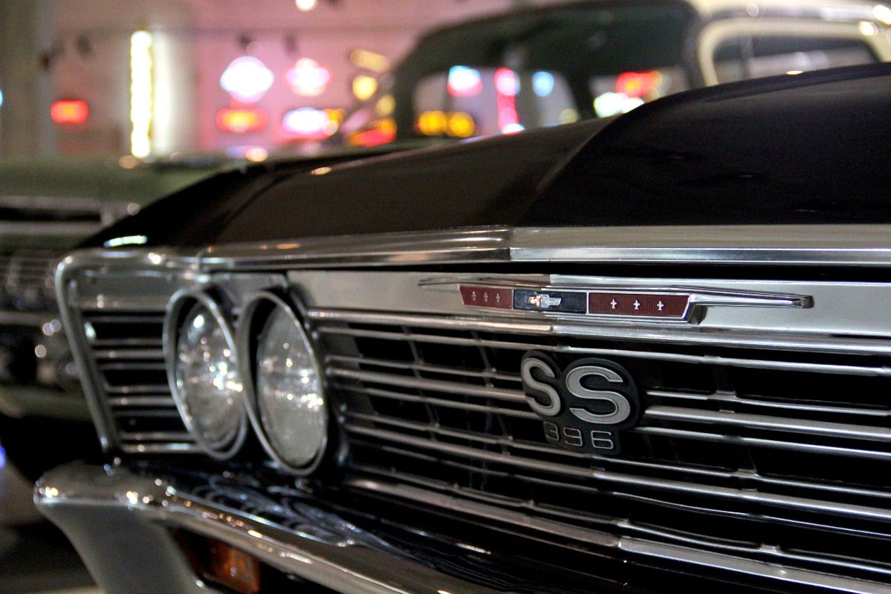 Close-up of the black-out grille of a dark 1967 Chevrolet El Camino with the SS 396 grille badge, dual headlamps and chrome bumper