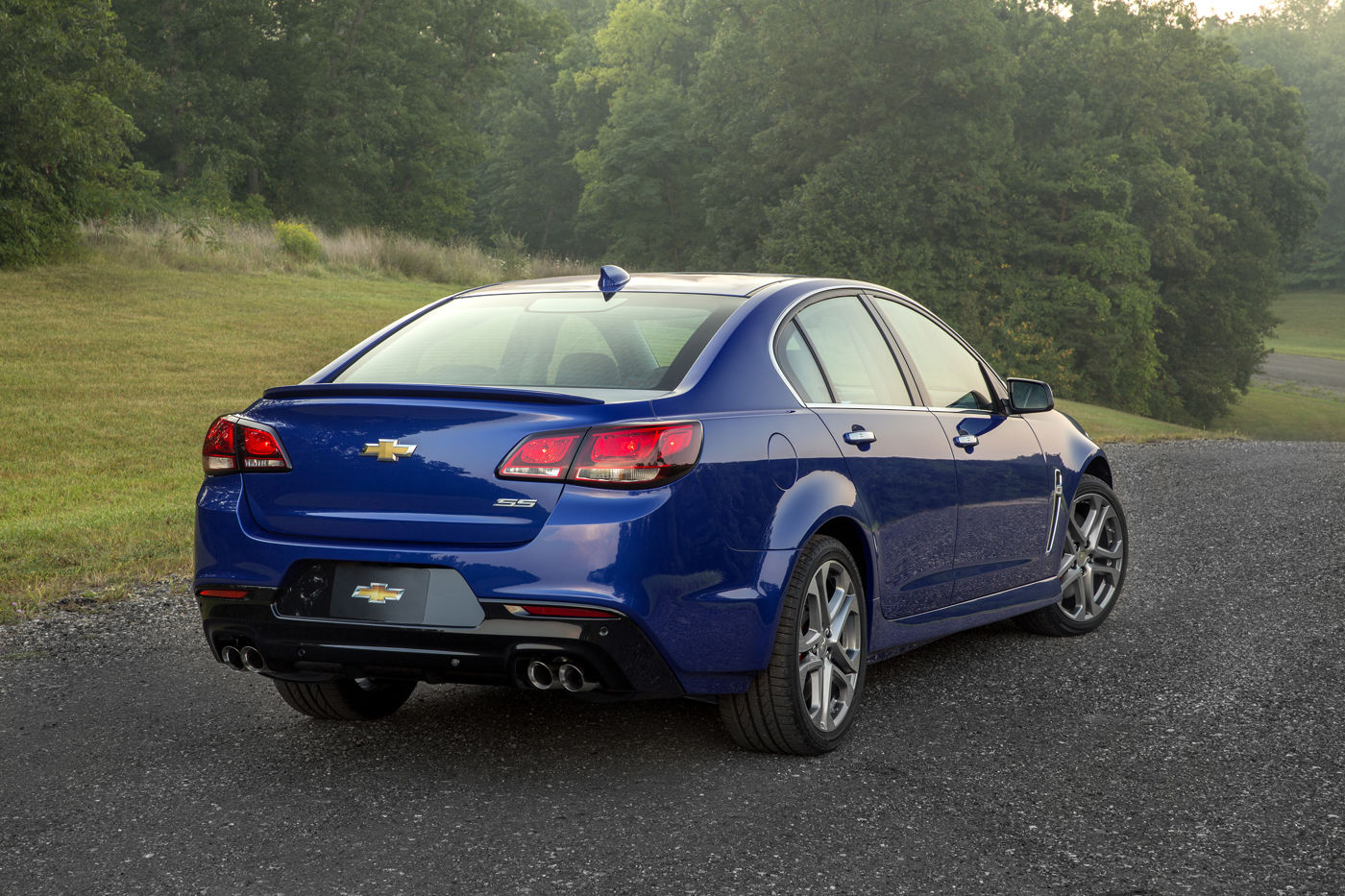 Blue 2016 Chevrolet SS sedan from the rear three-quarter, showing the SS trunk badge, decklid spoiler and quad exhaust outlets