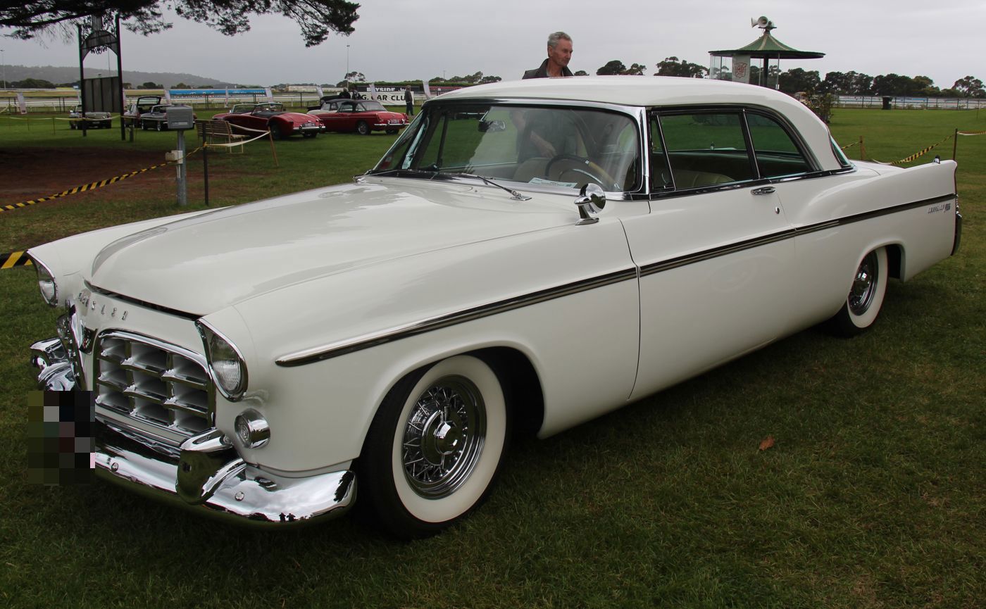 White 1956 Chrysler 300B hardtop with egg-crate grille and wire wheel covers, front three-quarter on grass