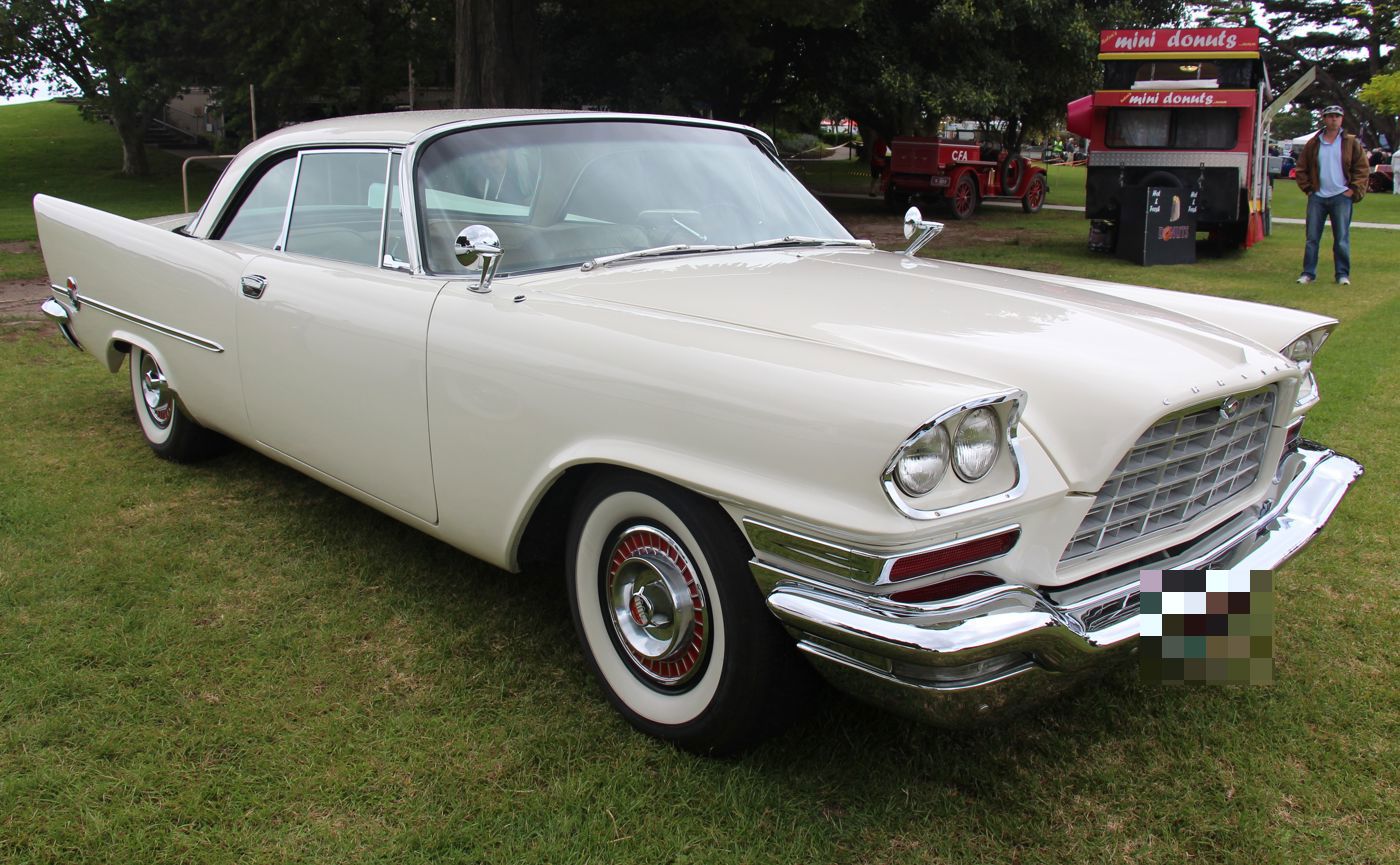 White 1958 Chrysler 300D hardtop with trapezoid grille and quad headlamps, front three-quarter on grass