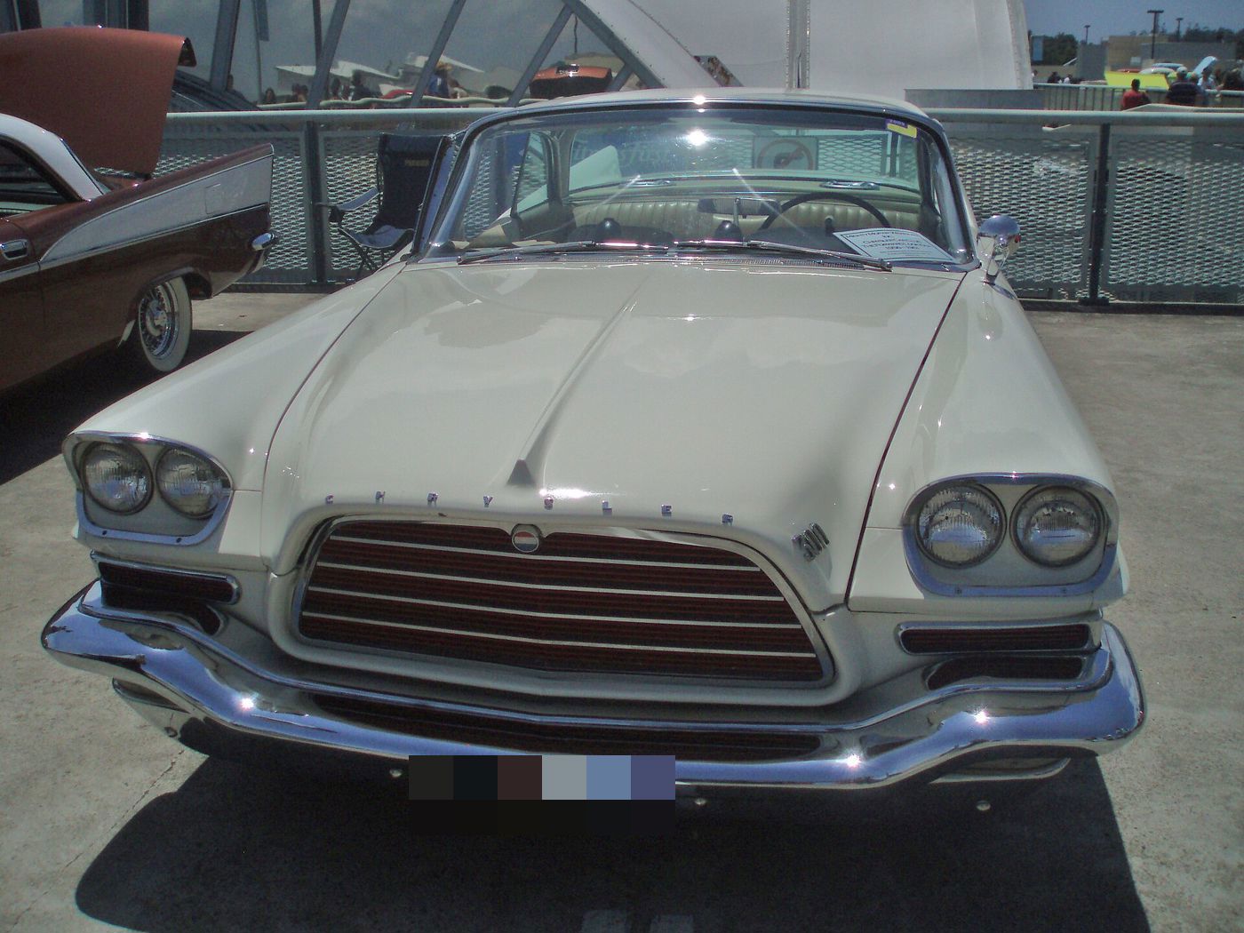 Head-on view of a white 1959 Chrysler 300E with its wide grille and quad headlamps