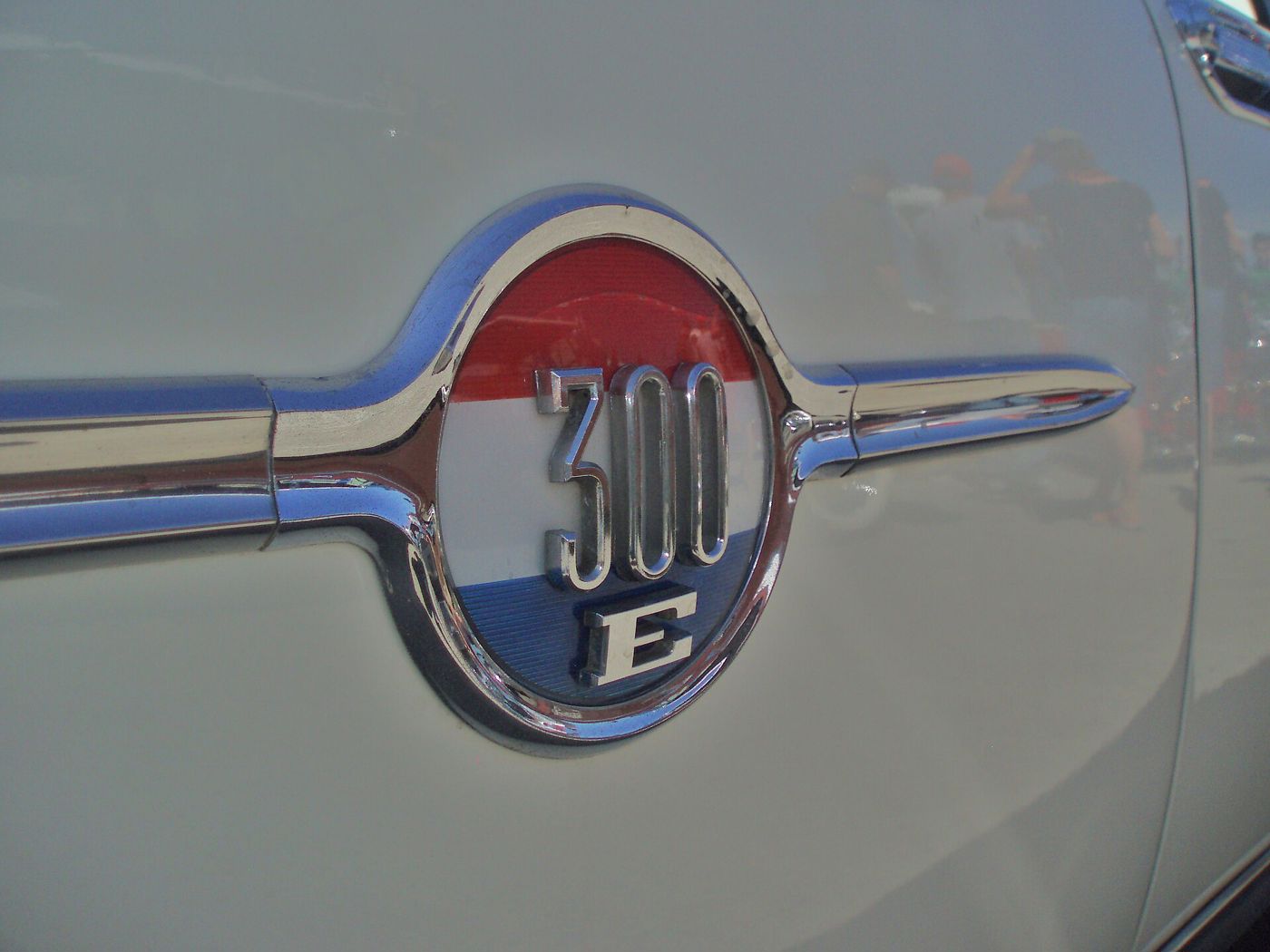 Close-up of the circular 300 E medallion with red, white and blue enamel on a white 1959 Chrysler