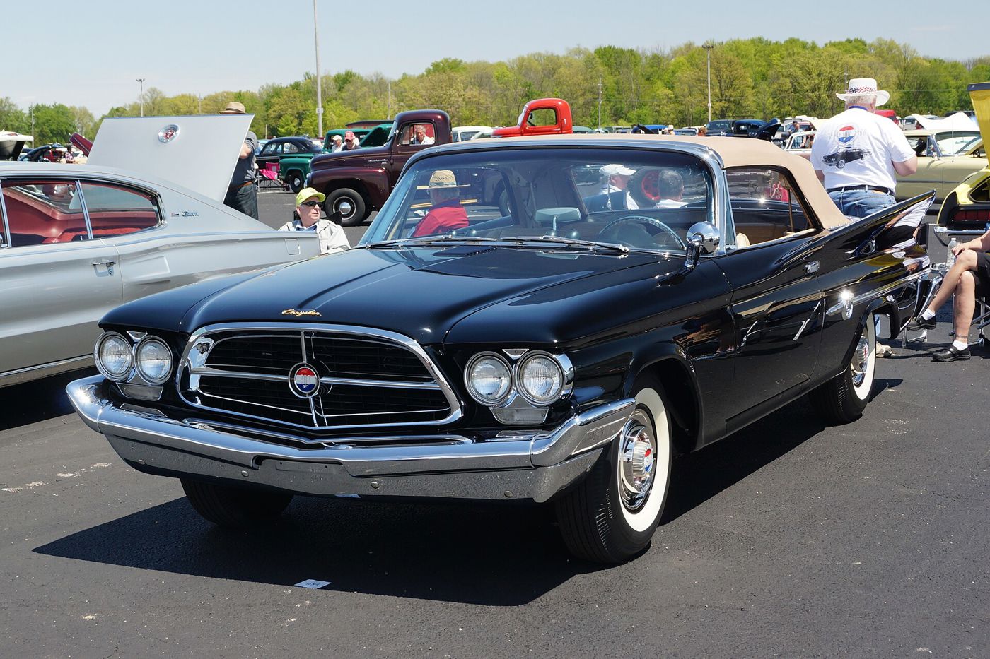 Black 1960 Chrysler 300F convertible with the canted-headlamp front end and centre medallion, at an outdoor car show