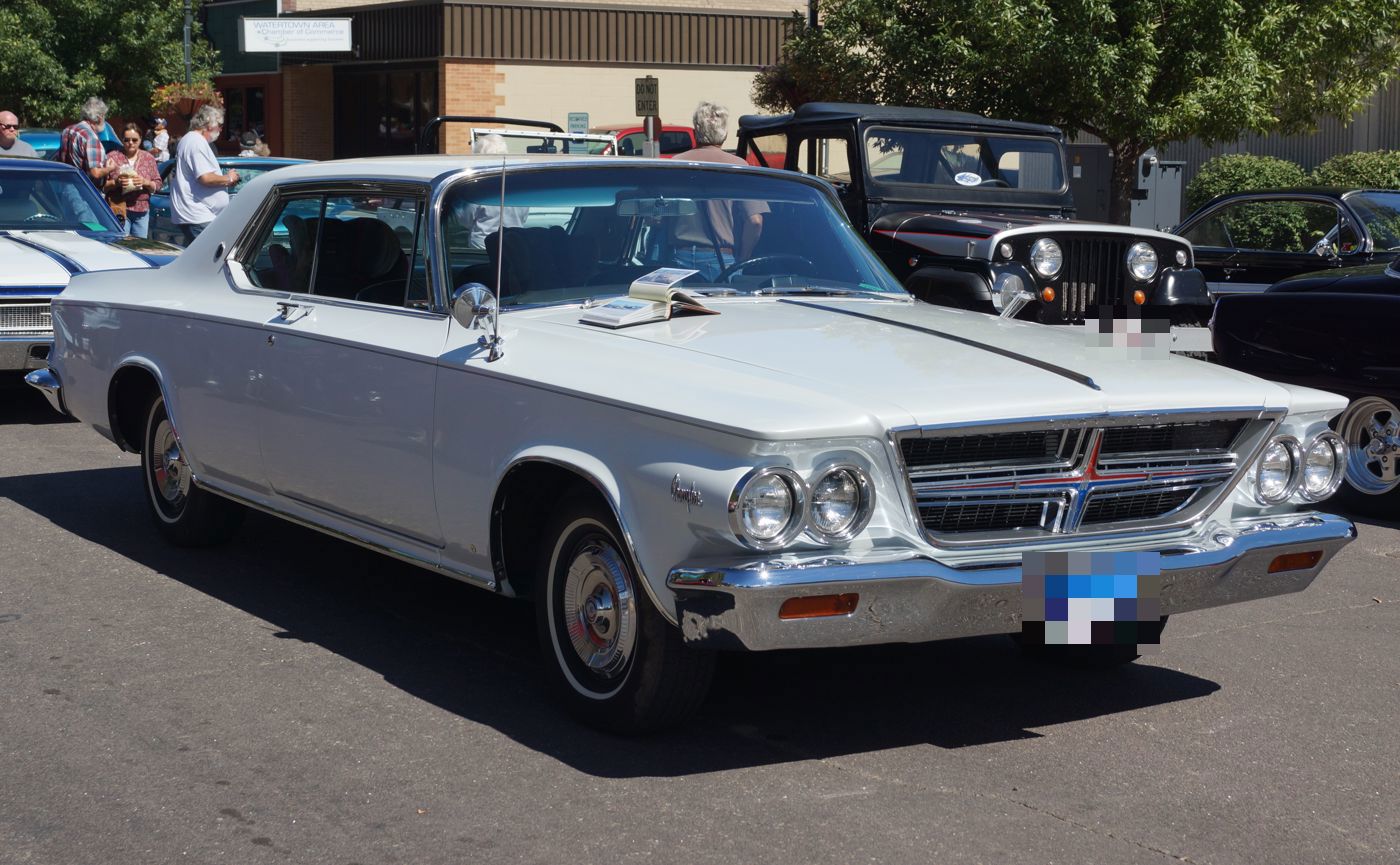 White 1964 Chrysler 300K with a dark stripe on the hood and bodyside, front three-quarter at a street show