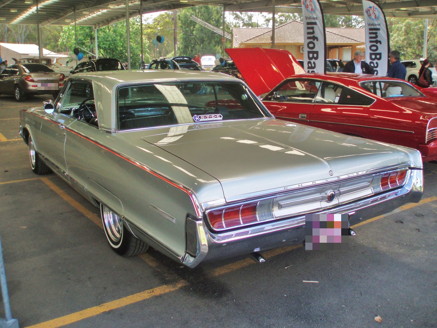 Silver 1965 Chrysler 300L hardtop from the rear three-quarter, showing the full-width taillamp panel