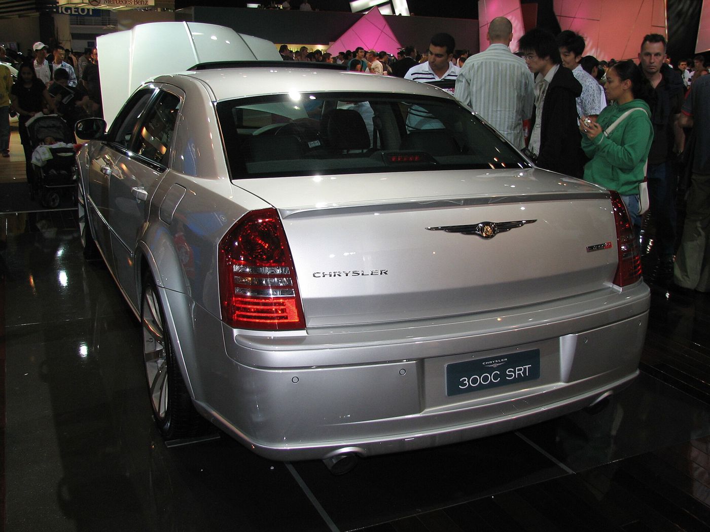 Silver 2006 Chrysler 300C SRT8 at a crowded indoor motor show, rear three-quarter with a 300C SRT display plate