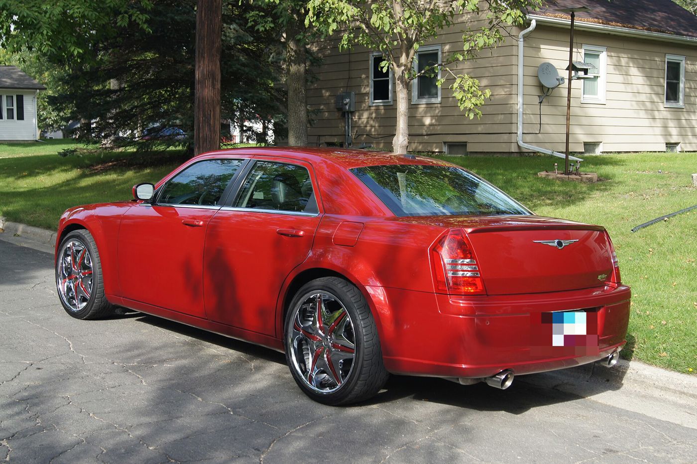 Red 2007 Chrysler 300C SRT8 sedan parked at a kerb, seen from the rear three-quarter with chrome aftermarket wheels