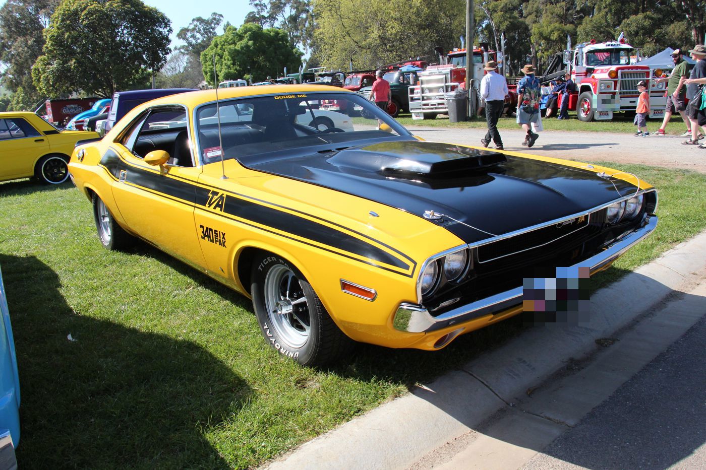 Yellow 1970 Dodge Challenger T/A with black side stripe, T/A and 340 SIX PAK lettering, and fibreglass hood scoop, front three-quarter