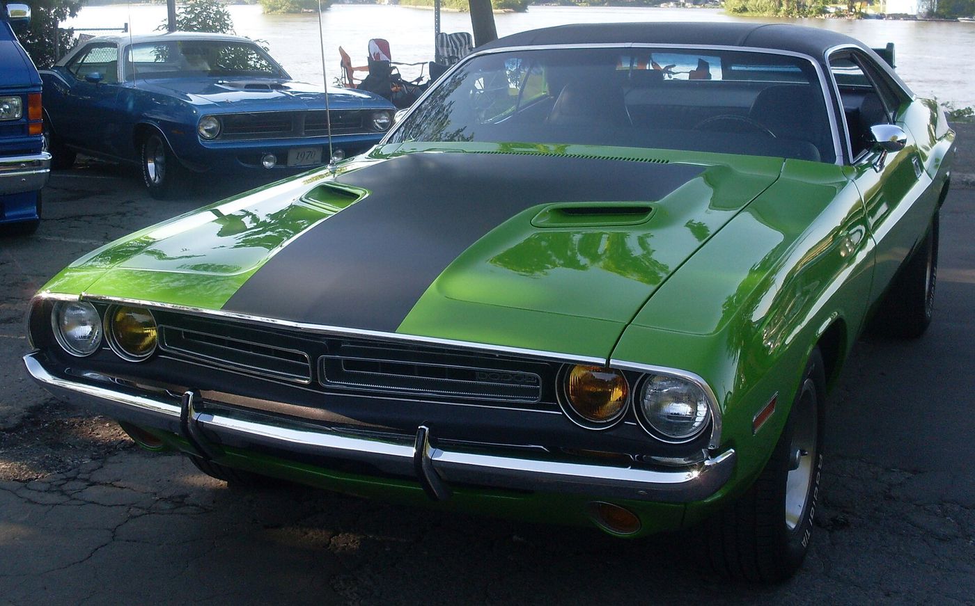 Green 1971 Dodge Challenger with black hood seen from the front, showing the twin-section 1971 grille and quad headlamps