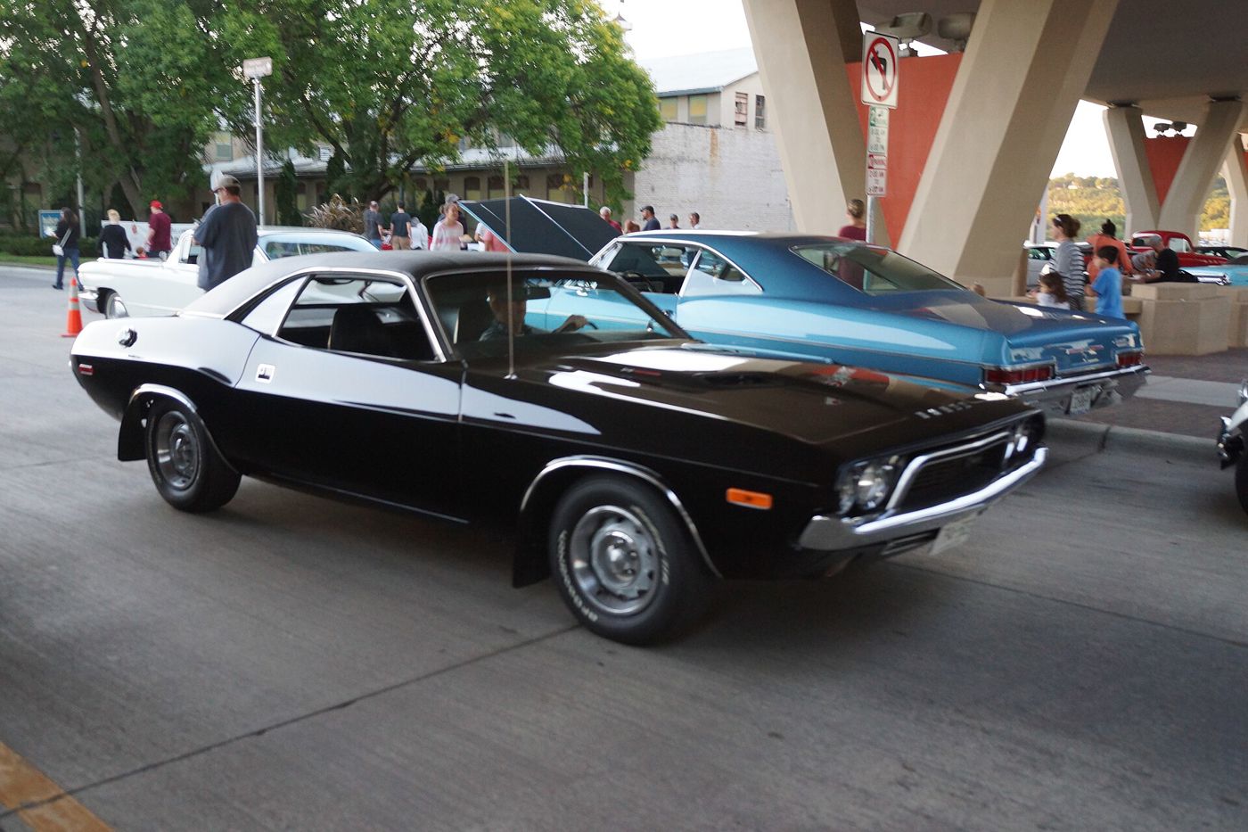 Black 1972 Dodge Challenger with white side stripe graphic, front three-quarter in a car show lot