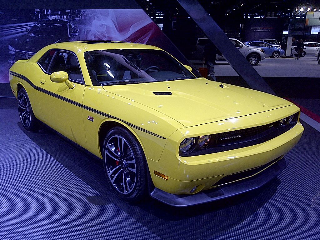 Yellow 2012 Dodge Challenger SRT8 Yellow Jacket with black side stripe on an auto show stand