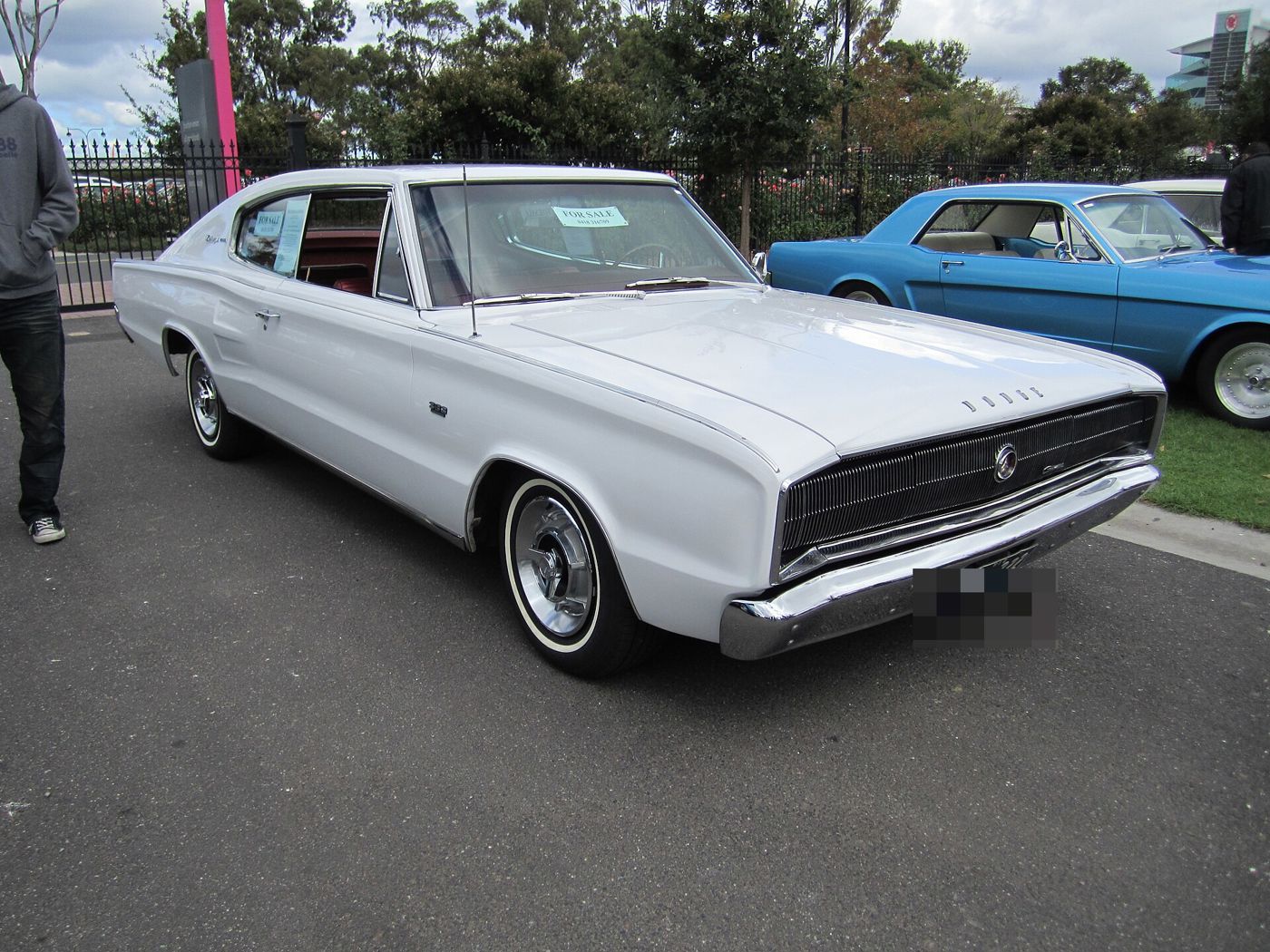 White 1966 Dodge Charger fastback from the front three-quarter, showing the full-width grille with hidden headlamps