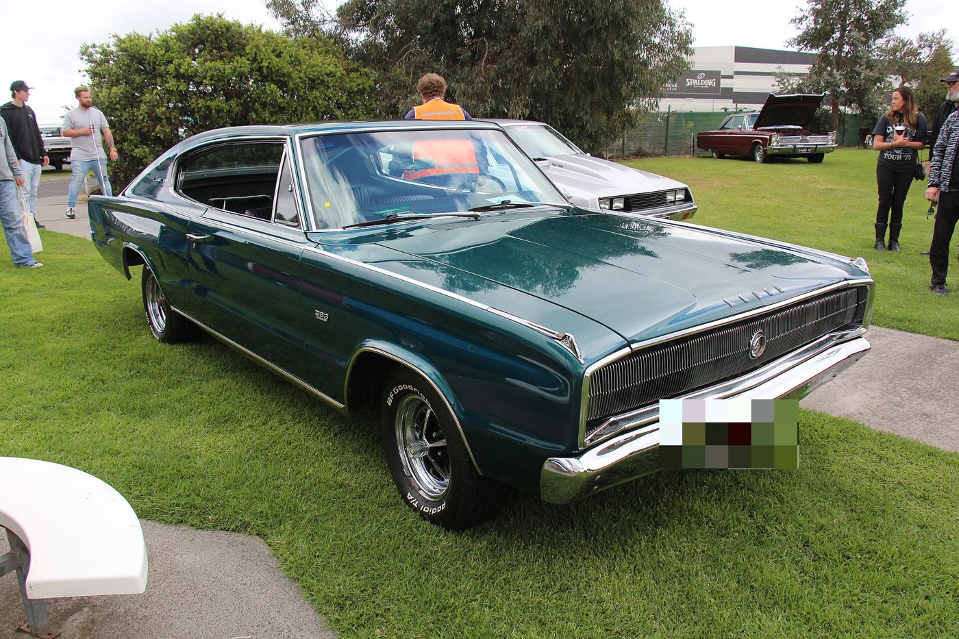 Dark green 1967 Dodge Charger fastback from the front three-quarter at an outdoor car show