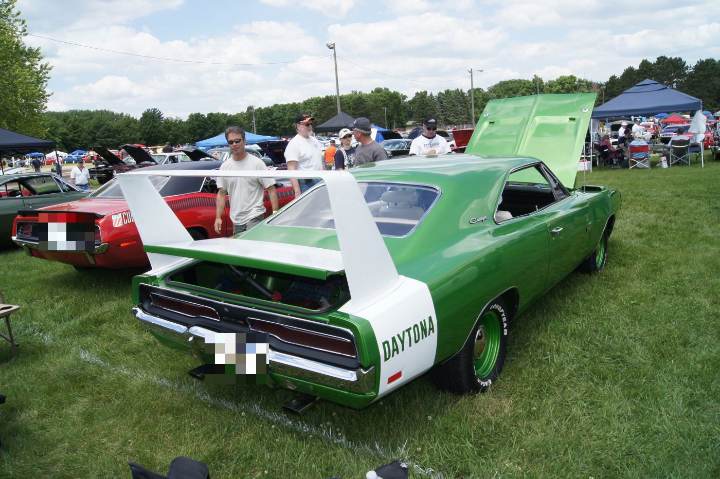 Rear of a green 1969 Dodge Charger Daytona showing the tall white rear wing and the DAYTONA lettering on the quarter panel