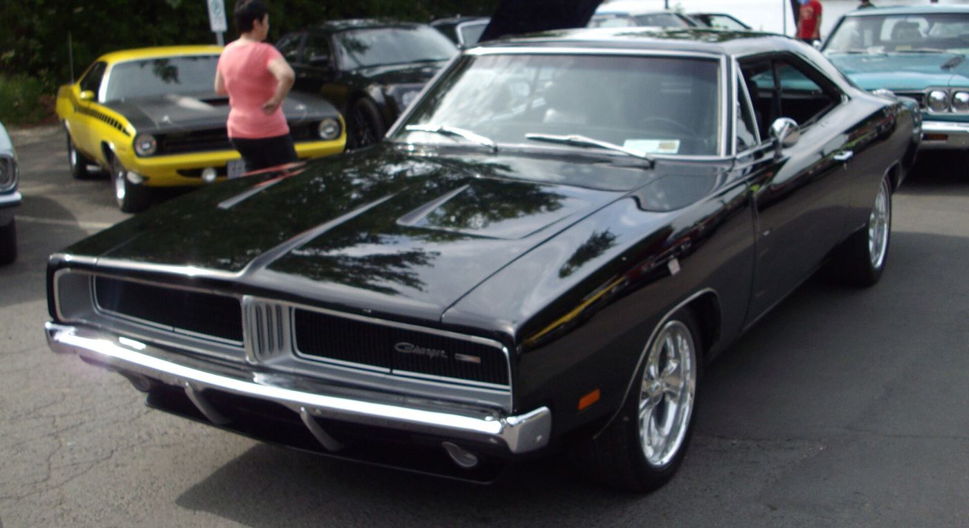 Black 1969 Dodge Charger from the front three-quarter, showing the split grille with hidden headlamps