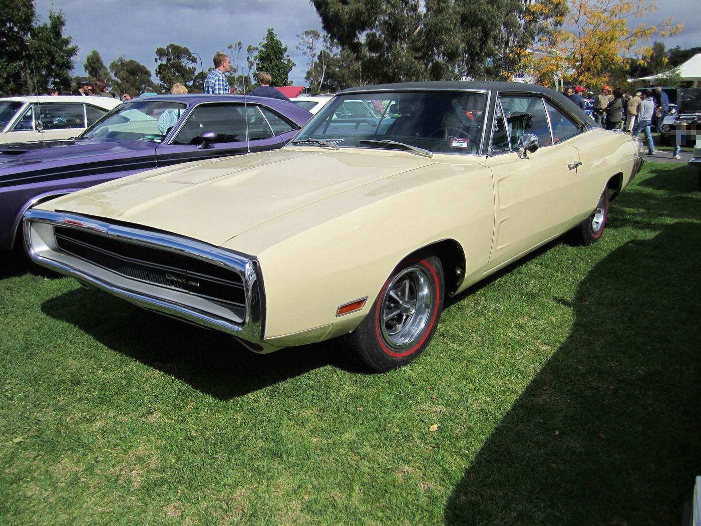 Cream 1970 Dodge Charger with black vinyl roof, front three-quarter, showing the 1970-only chrome loop bumper around the grille