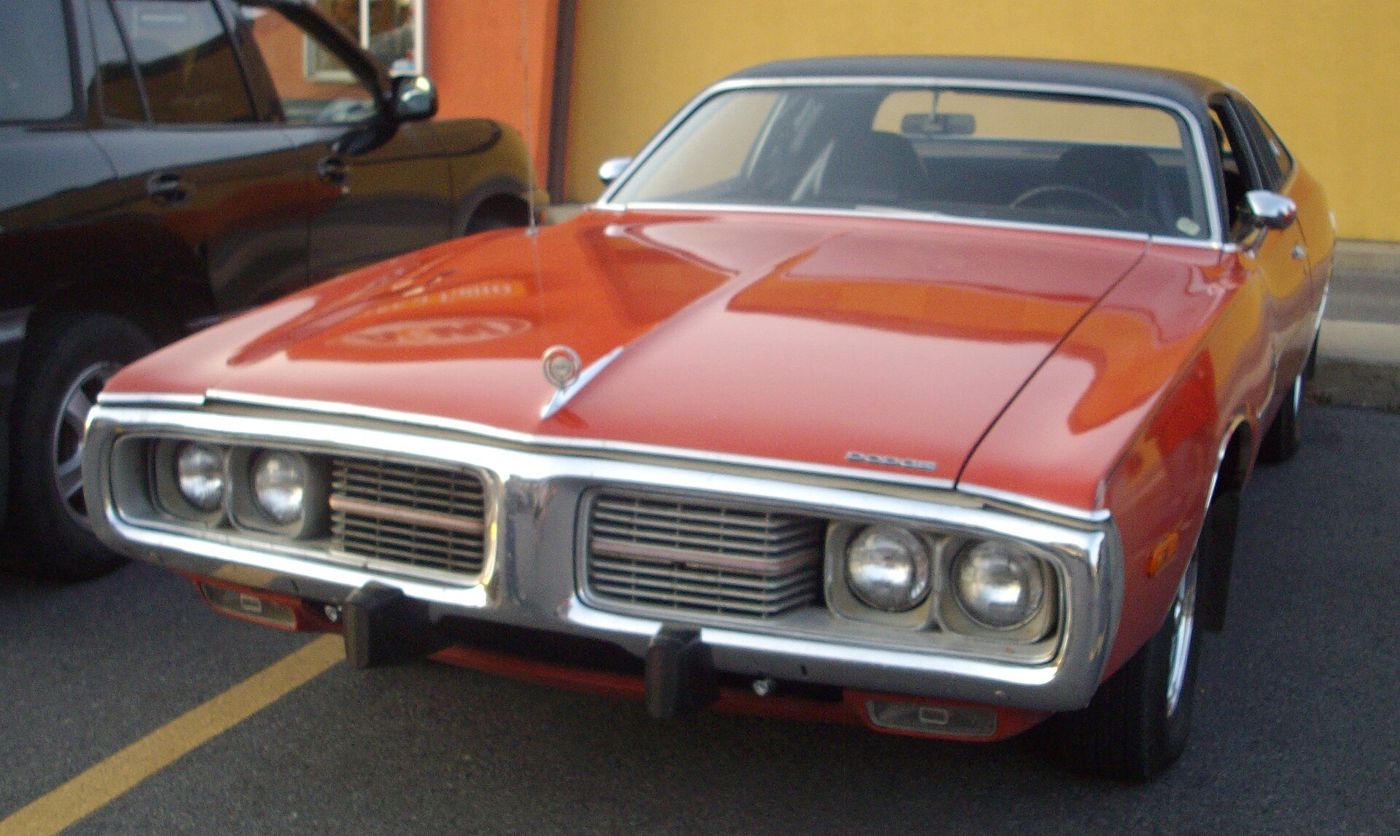 Red 1973 Dodge Charger with black vinyl roof and quad headlamps, front three-quarter view