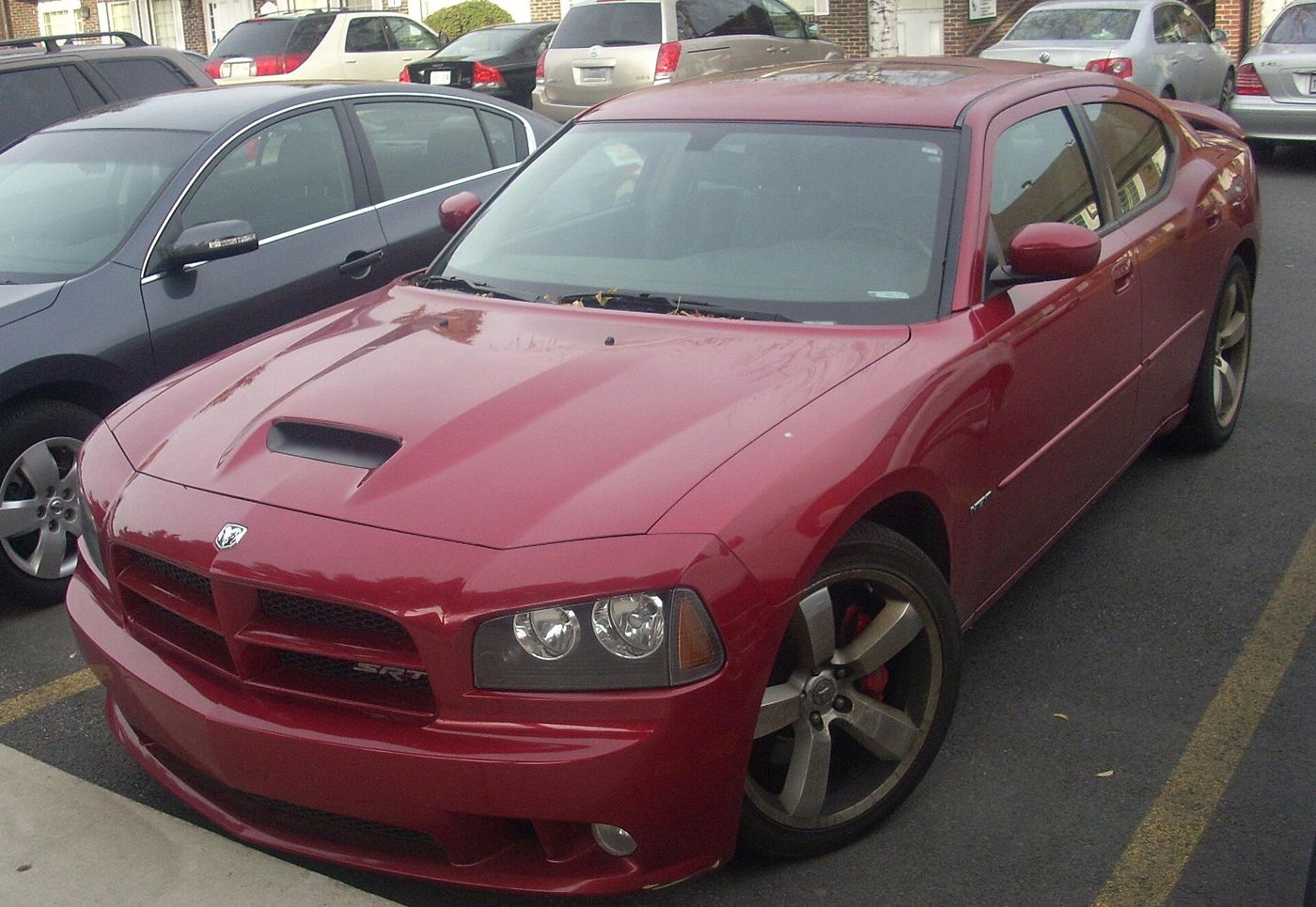 Dark red LX-generation Dodge Charger SRT8 with hood scoop and SRT8 grille badge, front three-quarter