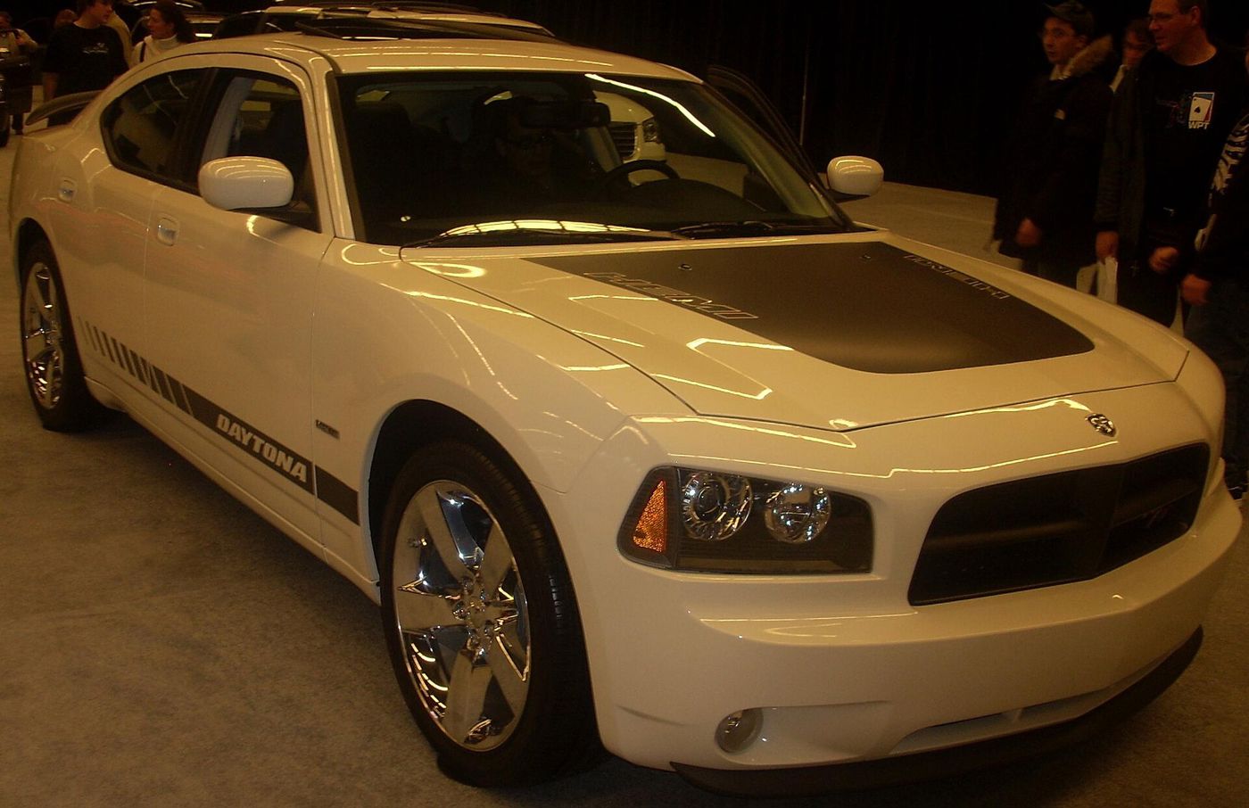 White 2008 Dodge Charger Daytona R/T with black hood and DAYTONA lettering on the lower door, at an auto show