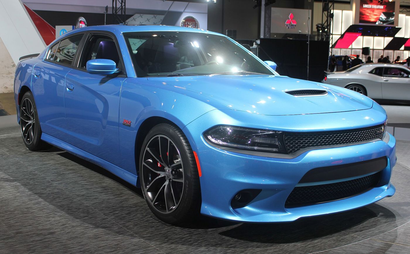 Bright blue 2015 Dodge Charger SRT 392 with hood scoop and thin LED-ringed headlamps, at an auto show