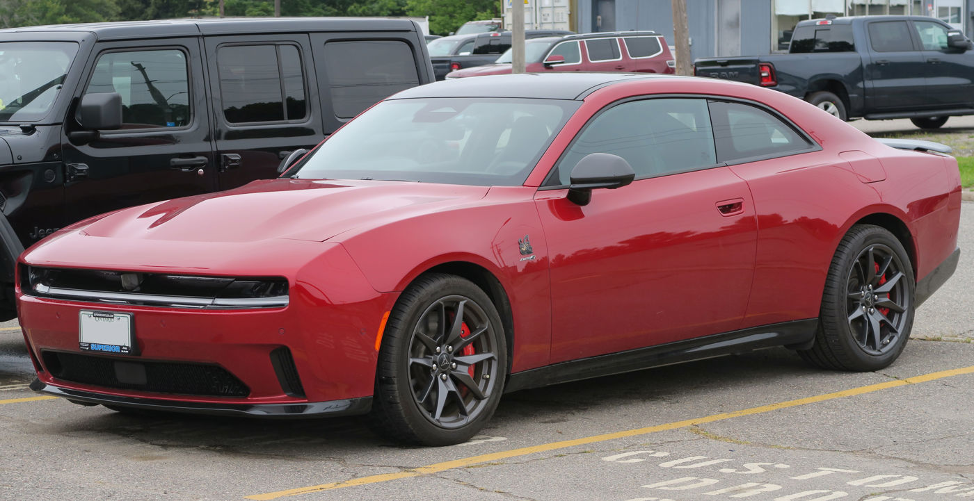 Red 2024 Dodge Charger Daytona Scat Pack electric coupe with the full-width light bar and pass-through front wing