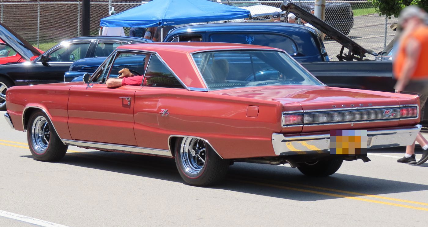 Red 1967 Dodge Coronet R/T from the rear three-quarter, showing the R/T tail panel and fender badge