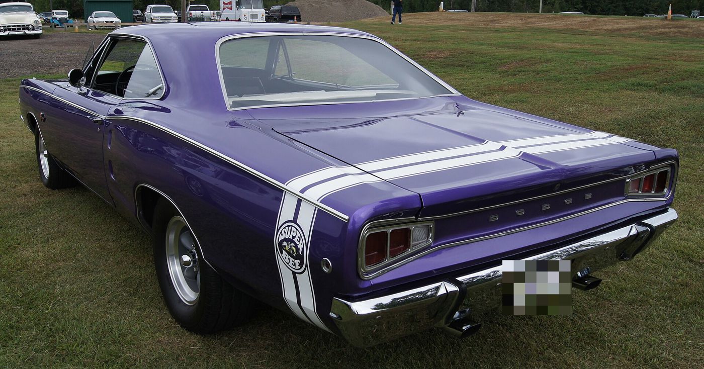 Purple 1968 Dodge Coronet R/T from the rear three-quarter showing the white bumblebee stripe around the tail