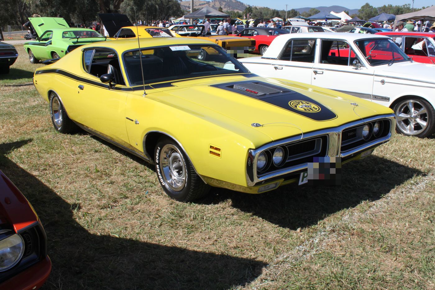 Yellow 1971 Dodge Charger Super Bee with black hood graphic bearing the Super Bee emblem, front three-quarter