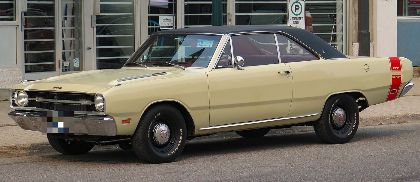 Cream 1969 Dodge Dart GTS with black vinyl roof and red rear stripe, seen in profile at the kerb